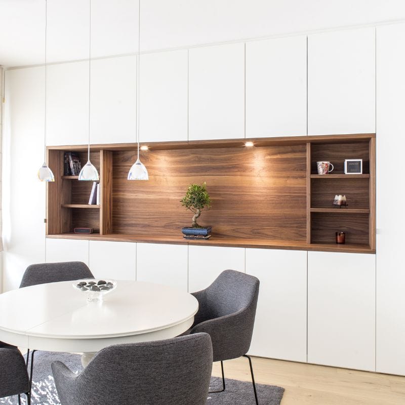 Mur de rangement salon, façades blanches et ouverture en bois de noyer