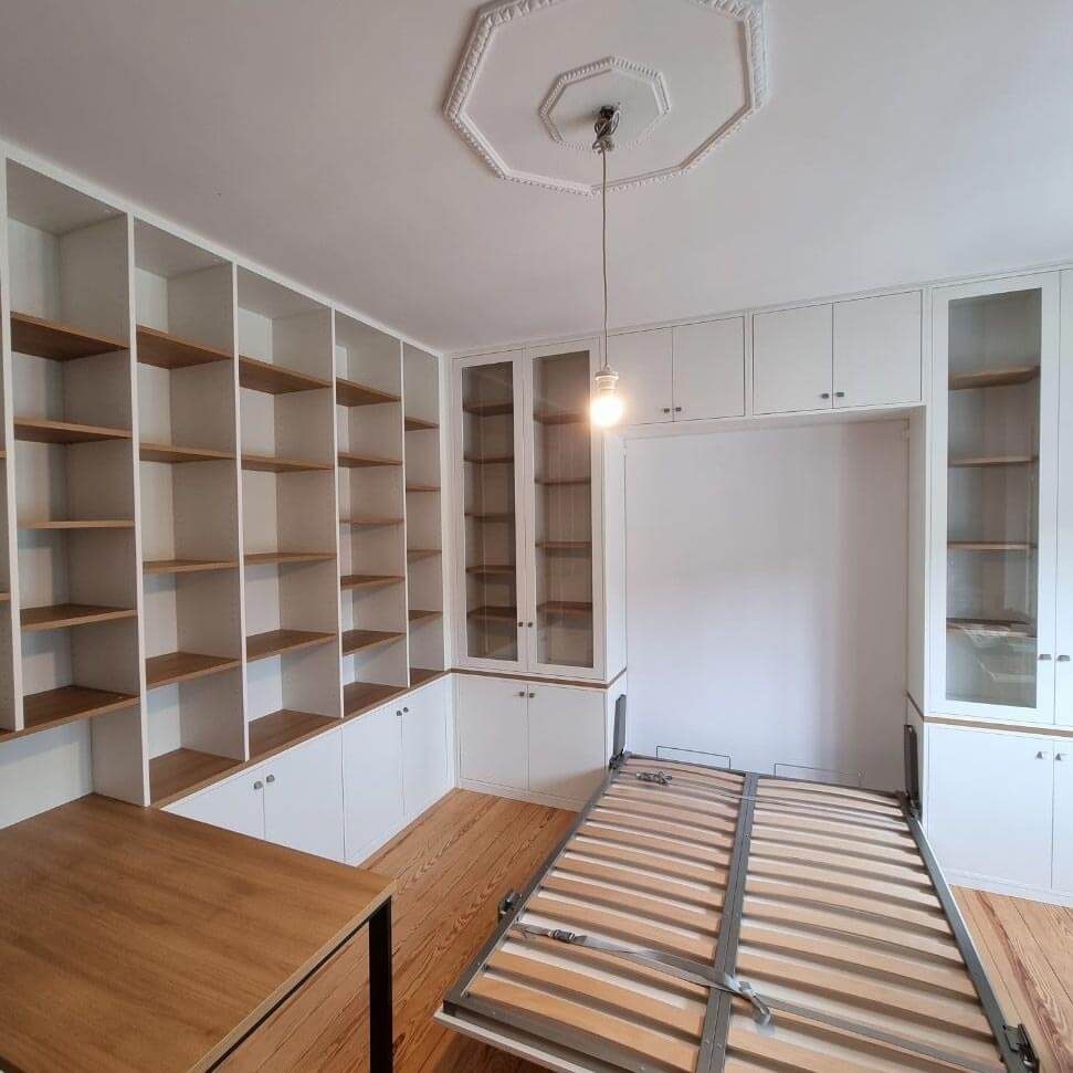 Grande bibliothèque avec vitrines et lit intégré dans un placard
